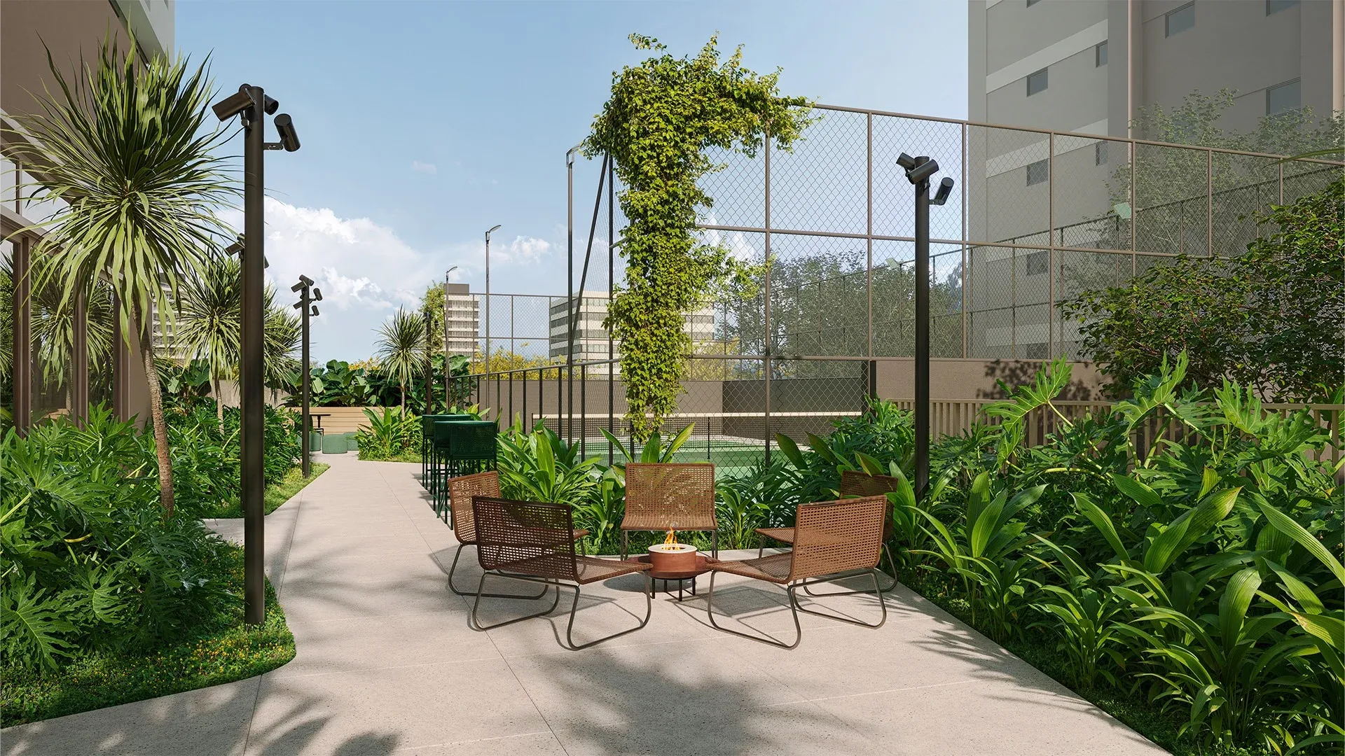Lounge externo com lareira e quadra ao fundo no 1º pavimento do Alameda Mará em Moema, com poltronas e paisagismo tropical.